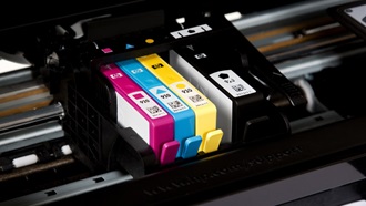 Parte interior de uma impressora com quatro tinteiros a descoberto das cores magenta, ciano, amarelo e preto.